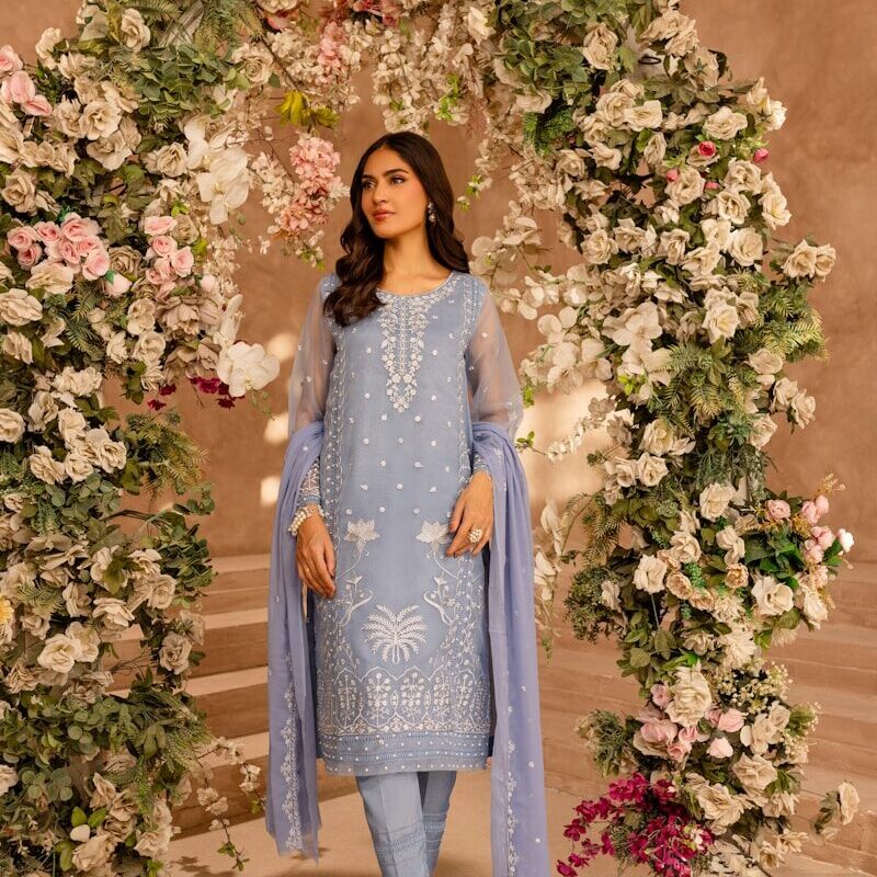 A woman standing in front of a floral archway